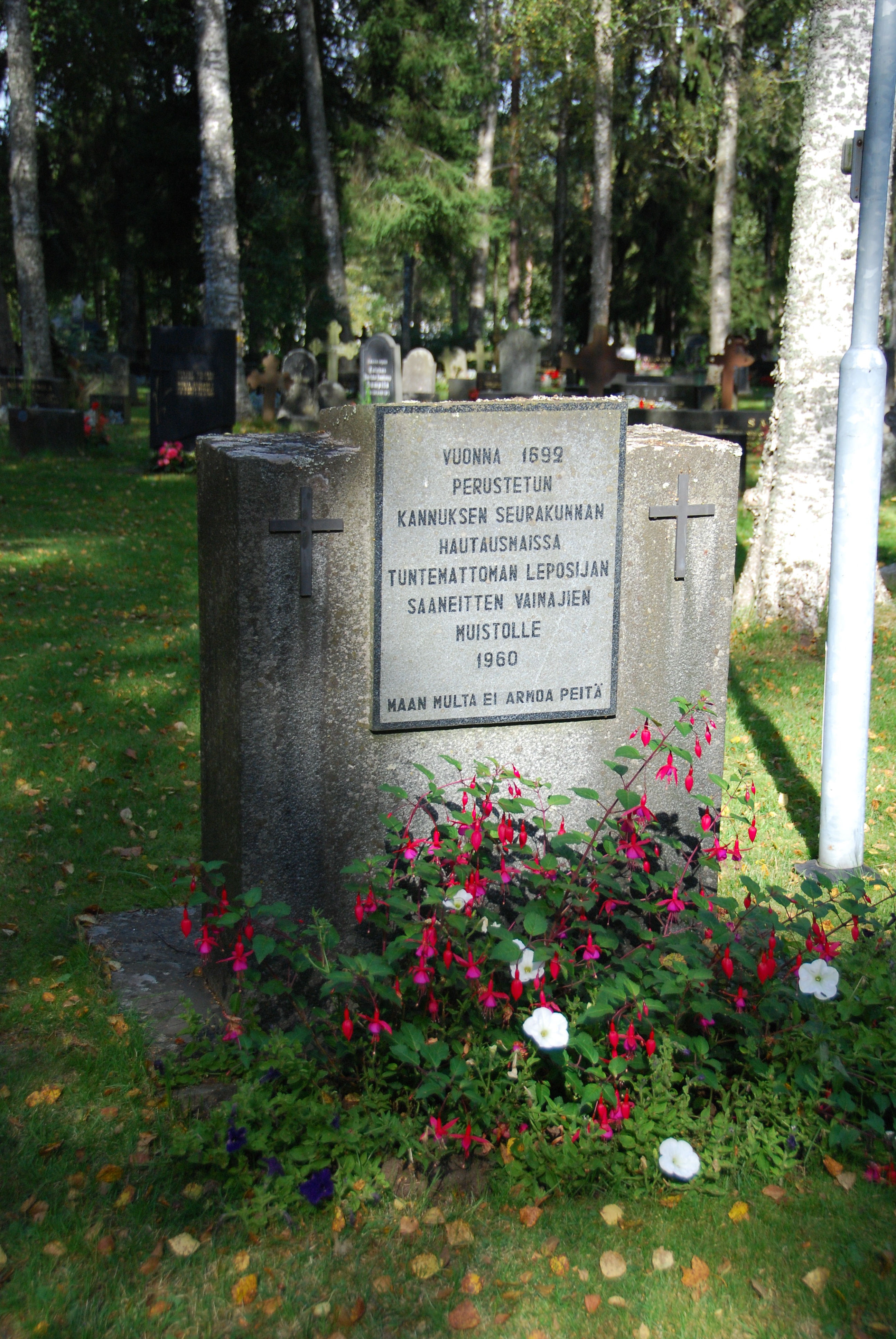 Muistokivi, teksti: vuonna 1692 perustetun Kannuksen seurakunnan hautausmaissa tuntemattoman leposijan saaneitten vainajien muistolle 1960.